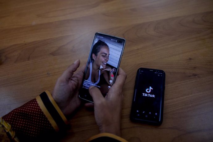 Una persona mira en su móvil el vídeo de una joven en la red musical Tik Tok, en Madrid (España), a 22 de septiembre de 2020. TikTok ha publicado este martes su tercer Informe de Transparencia, que recoge la actividad del primer semestre de 2020, en el 