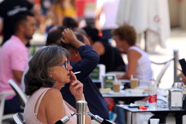 Personas fumando en terrazas y vías públicas  durante el día en el que se ha decretado la prohibición de fumar en espacios públicos si no se respeta la distancia de seguridad establecida. Málaga a 14 de agosto del 2020