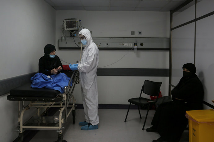 17 November 2020, Lebanon, Beirut: A medic wearing full protective gear checks a woman who might have contracted coronavirus inside an emergency room at the Rafic Hariri Hospital. 
