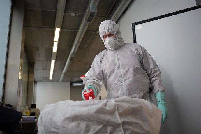 Un operario del Crematorio de Girona desinfecta el cuerpo de una persona fallecida con COVID-19 y su ataúd, antes de introducirle en el horno crematorio. En Girona, Cataluña, (España), a 6 de mayo de 2020.