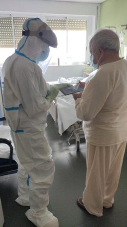 Un profesional sanitario con un enfermo de covid-19 