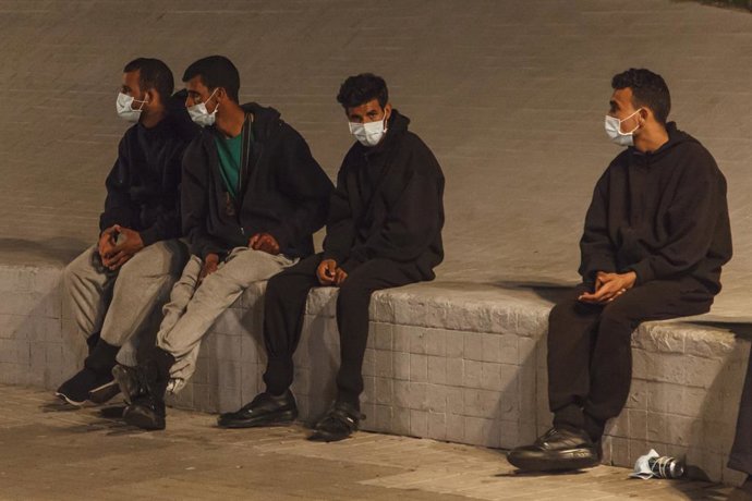 Inmigrantes desalojados del muelle de Arguineguín llegan frente a la delegación del Gobierno en Las Palmas de Gran Canaria, en un dispositivo de seguridad dirigido por la Policía Nacional, a 17 de noviembre de 2020. Unos 200 migrantes de origen magrebí 