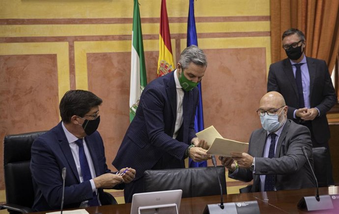 El vicepresidente de la Junta, Juan Marín (i), y el consejero de Hacienda, Juan Bravo (c), firman el acuerdo para aprobar los Presupuestos de 2021 con el portavoz parlamentario de Vox, Alejandro Hernández (d). En Sevilla a 18 de noviembre de 2020.