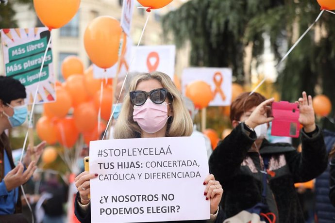 Una mujer sostiene una pancarta durante una nueva concentración convocada ante el Congreso contra la LOMLOE, la reforma de la ley educativa conocida como 'ley Celaá', en Madrid