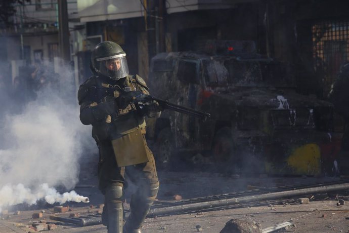Un agente de Carabineros con una escopeta antidisturbios en medio de gases lacrimógenos durante una protesta en Concepción en noviembre de 2019