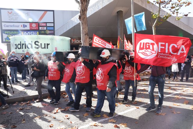 Un grupo de trabajadores sostienen un ataúd como signo de protesta en una concentración convocada frente a la Asamblea de Madrid convocada por CC.OO. y UGT