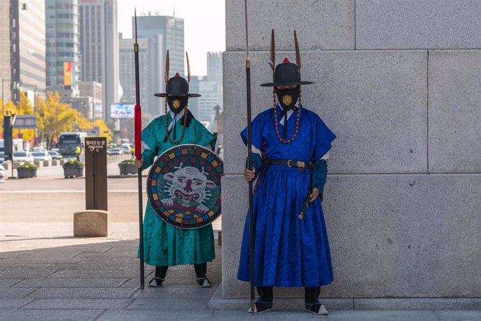 Dos guardias reales con mascarilla en la puerta principal del Palacio Gyeongbokgung, en Seúl