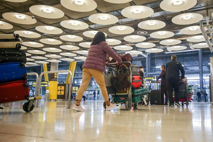 Varios pasajeros caminan por las instalaciones de la T4 del Aeropuerto Adolfo Suárez Madrid-Barajas, en Madrid, (España), a 12 de noviembre de 2020. En plena segunda ola de la pandemia del Covid-19, desde este jueves tal y como recoge el Boletín Oficial