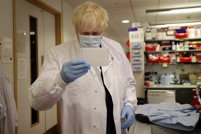 FILED - 18 September 2020, England, Oxford: UK Prime Minister Boris Johnson holds an immunological assay testing plate during his visit to Jenner Institute, where he meets with scientists who are leading the coronavirus (COVID-19) vaccine research.