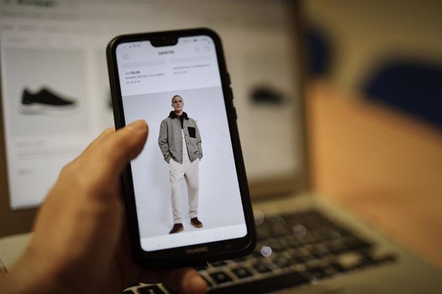 Una persona observa en su móvil artículos de moda en la página de un comercio 'online'