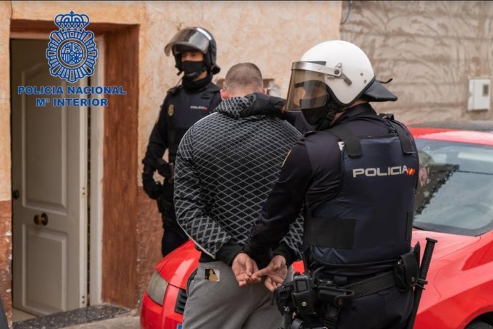 Imagen de uno de los detenidos, custodiados por la Policía Nacional
