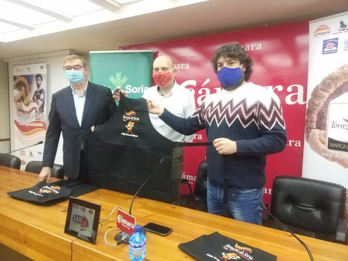 De izda a dcha, Samuel Moreno, Juanjo Delgado y Rubén García presentan el delantal solidario de Torrezno de Soria.