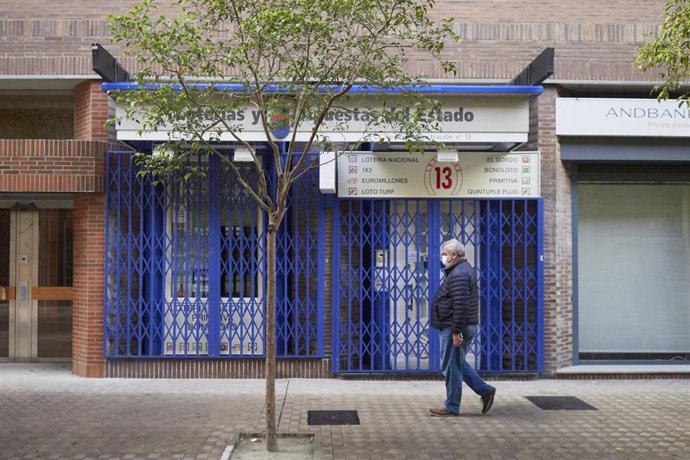 Transeúntes pasean por una calle protegidos con mascarilla debido a la crisis sanitaria del Covid-19