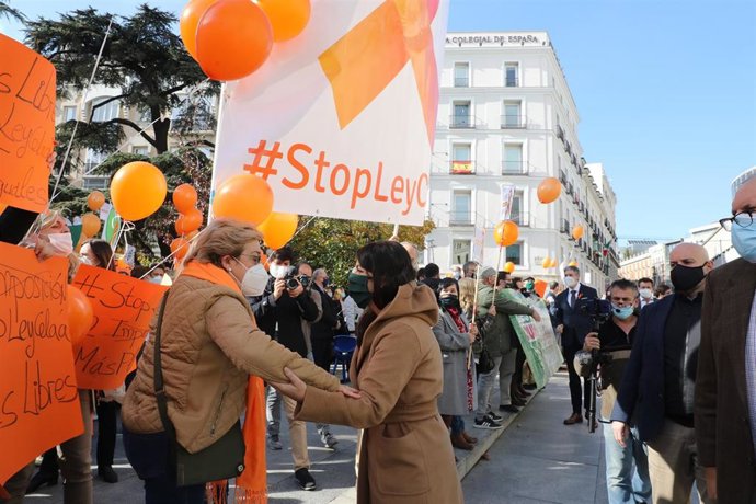 La secretaria general de Vox en el Congreso de los Diputados, Macarena Olona (d), saluda a una mujer durante una nueva concentración convocada ante el Congreso contra la LOMLOE, la reforma de la ley educativa conocida como 'ley Celaá', en Madrid