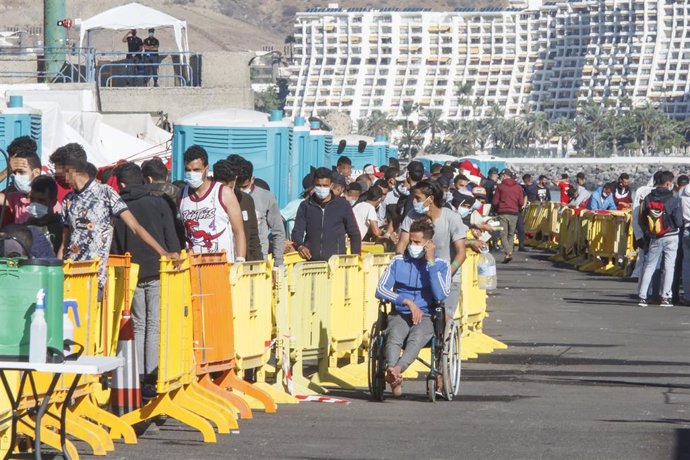 Varios inmigrantes hacen cola en el Muelle de Arguineguín, en Gran Canaria, Canarias (España).