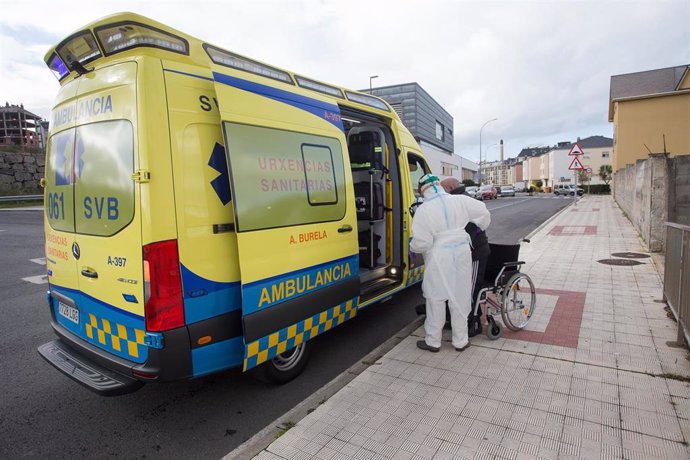 Un trabajador sanitario totalmente protegido ayuda a subir a la ambulancia a un anciano de la residencia de ancianos de San Cibrao donde se ha originado un brote de Covid-19, en San Cibrao, Lugo, Galicia, (España), a 9 de noviembre de 2020. En el centro