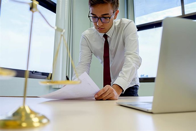 Trabajador del sector de la justicia con un ordenador en un despacho