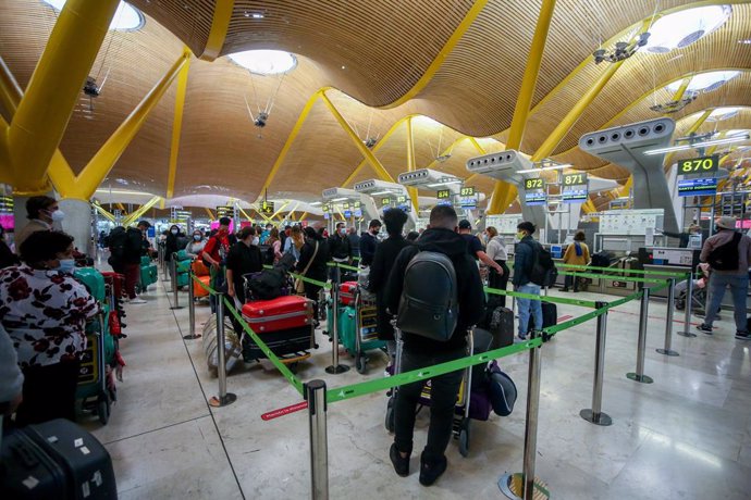 Filas de pasajeros esperan para dejar su maleta antes de embarcar en el avión en la T4 del Aeropuerto Adolfo Suárez Madrid-Barajas, en Madrid, (España).