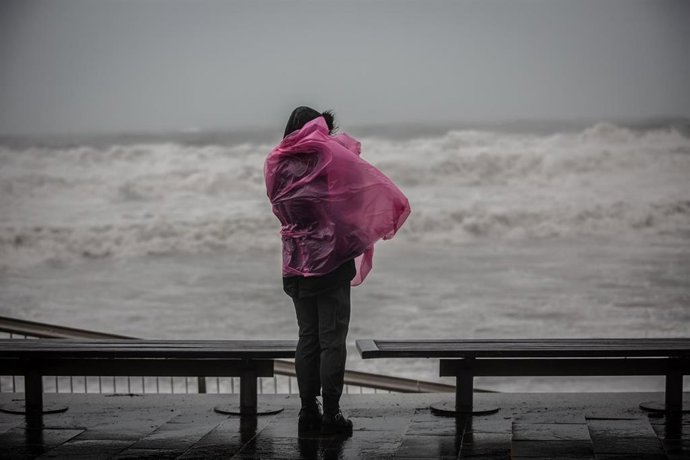 Una mujer en el paseo marítimo de Barcelona, donde la borrasca 'Gloria' ha dejada fuertes lluvias, a 21 de enero de 2020.