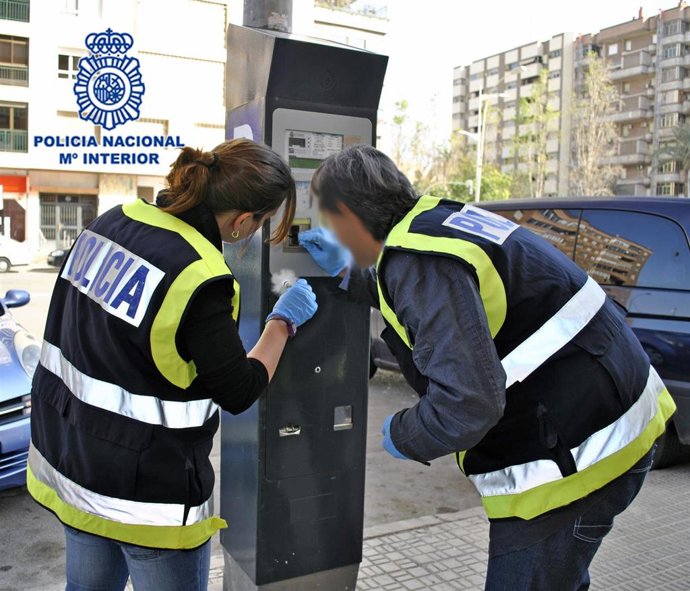Agentes de Policía Nacional realizan un inspección en un parquímetro de la ORA en Cartagena tras soprender a un hombre forzando la máquina con una palanca y un destornillador