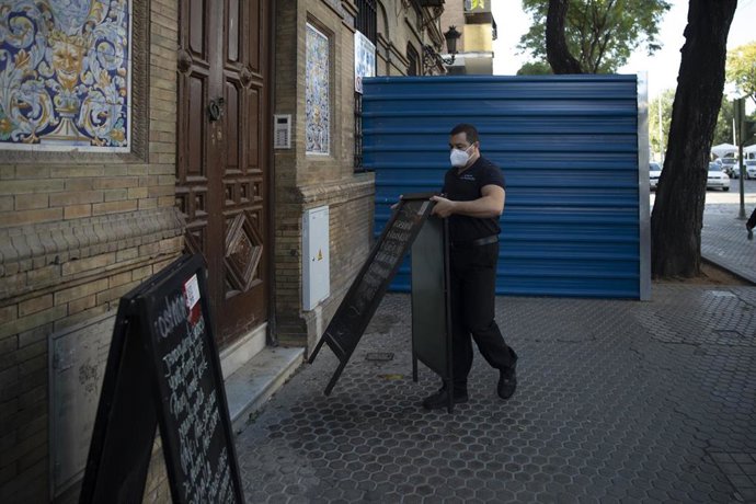 Camareros recogiendo las mesas de un bar.