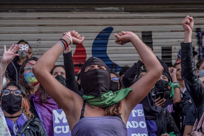 14 September 2020, Mexico, Mexico City: Feminist activists raise their fists and shout slogans during a protest against violence against women in front of the main office of the State Human Rights Commission. Photo: Jacky Muniello/dpa
