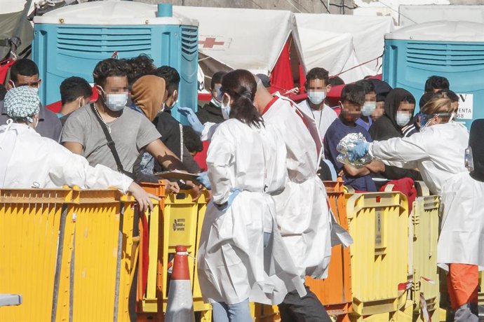 Diversos immigrants són atesos per personal sanitari en el Moll d'Arguineguín, a Gran Canria.