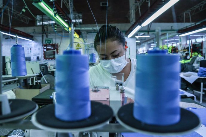 30 March 2020, Colombia, Bogota: Aworker works on producing special protective suits to be used against the spread of the coronavirus, at a factory belonging to the Colombian National Police. Photo: Camila Diaz/colprensa/dpa