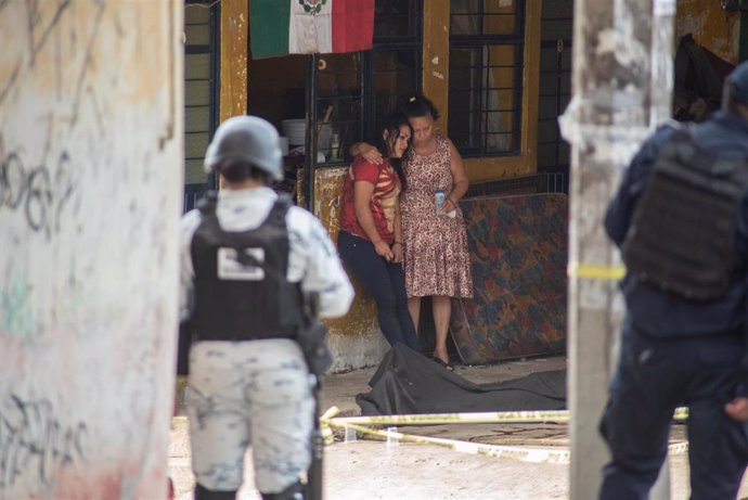 Dos mujeres junto al cadáver de un hombre abatido en Veracruz, México