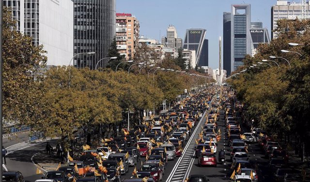 Varias personas muestran a través de sus coches banderas y globos de color naranja durante una manifestación de vehículos en apoyo a la educación concertada y contra la Ley Celaá, en Madrid (España), a 22 de noviembre de 2020. 