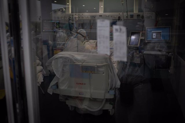 Trabajadores sanitarios protegidos atienden a un paciente en la Unidad de Cuidados Intensivos.