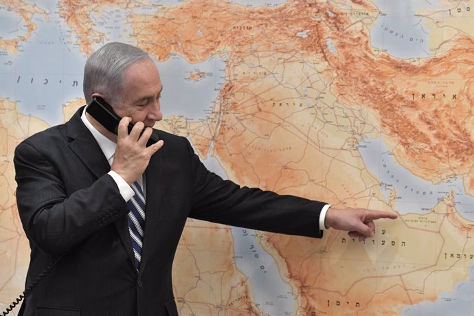 El primer ministro israelí, Benjamin Netanyahu, hablando por teléfono y señalando al golfo Pérsico en un mapa de Oriente Próximo