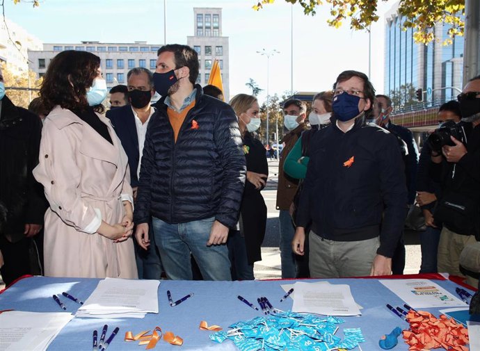 El presidente del Partido Popular, Pablo Casado, la presidenta de la Comunidad de Madrid, Isabel Díaz Ayuso, y el alcalde de Madrid, José Luis Martínez-Almeida, participan en una recogida de firmas en la caseta instalada por el PP en una manifestación d