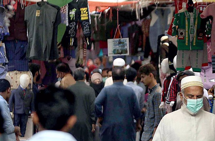 Personas con mascarilla en un mercado de Karachi