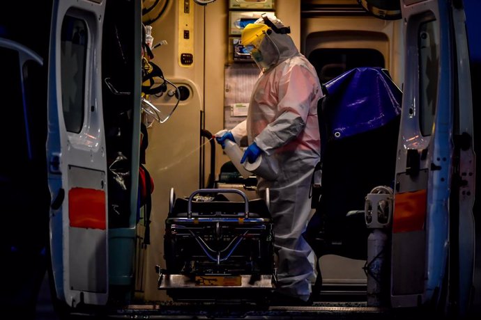 Un trabajador desinfecta una ambulancia en una campaña de test de coronavirus en Milán