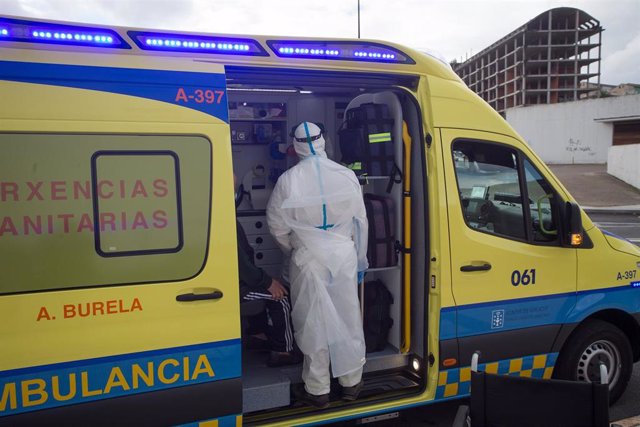 Un trabajador sanitario totalmente protegido ayuda a subir a la ambulancia a un anciano de la residencia de ancianos de San Cibrao donde se ha originado un brote de Covid-19, en San Cibrao, Lugo, Galicia, (España), a 9 de noviembre de 2020. En el centro l