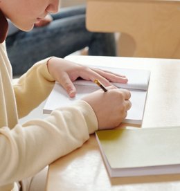 Estudiante escribiendo en clase