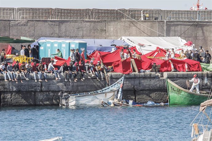 Varios inmigrantes en el Muelle de Arguineguín, en Gran Canaria, Canarias (España), a 18 de noviembre de 2020. Más de 2.300 migrantes permanecen hacinados en este muelle tras pernoctar en el campamento que se instaló el pasado mes de agosto en el recint