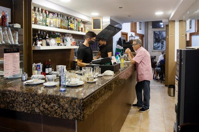 Un hombre desayuna en la barra del interior de un bar en Palma.
