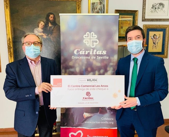 El gerente de Los Arcos,  Daniel Motilva, hace entrega de la cuantía recaudada en  el concierto navideño del centro comercial.