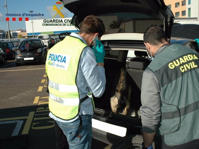 Agentes de la Guardia Civil registran el coche en el que estaba escondida la cocaína.