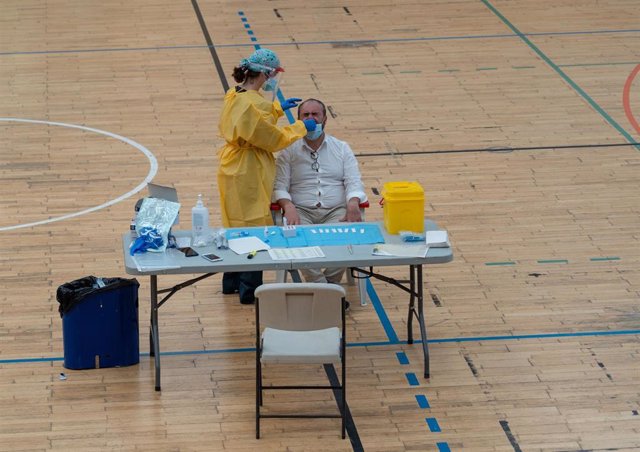 Sanitarios trabajando durante las pruebas de cribado de covid-19 con test de antígenos en el pabellón deportivo de 'El Paraguas'. En Sevilla (Andalucía, España), a 28 de octubre de 2020.