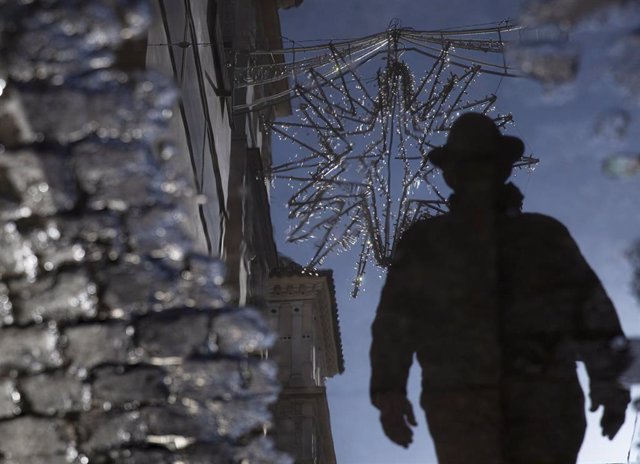El reflejo en un charco de agua de una estrella de iluminación navideña colocada en la calle cuna en Sevilla (Andalucía, España), a 20 de noviembre de 2020. El presidente de la Junta de Andalucía, Juanma Moreno, ha confiado este viernes en poder recuper