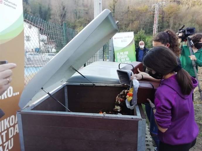Dos estudiantes del colegio público de Betelu depositan materia orgánica en el contenedor