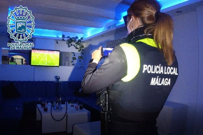 Agente de la Policía Local de Málaga desalojando un bar que incumplía la normativa