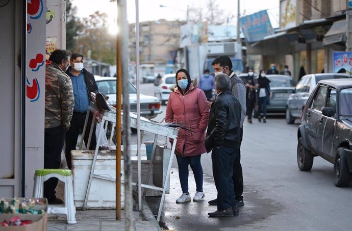 Personas con mascarillas en un mercado de Mashhad, Irán