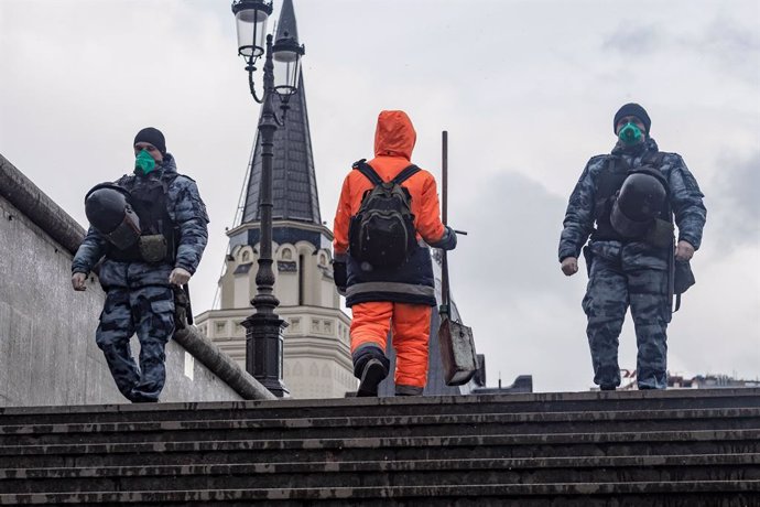 Dos oficiales de la Guardia Nacional rusa con mascarilla patrullando por el centro de Moscú