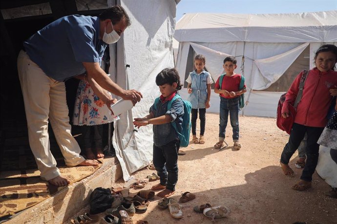 Desinfección a la entrada de una escuela en un campo de desplazados en Idlib