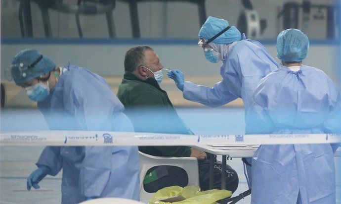 Un trabajador del SERMAS realiza un test de antígeno a un paciente en el Centro Deportivo Municipal Félix Rubio ubicado en Los Rosales, Villaverde, Madrid, (España), a 16 de octubre de 2020.