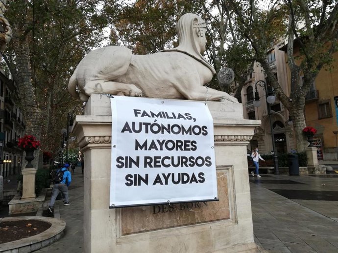 Pancarta reivindicativa encadenada a una de las esfinges del Born, en Palma.